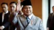 Indonesian President Prabowo Subianto waving while wearing a traditional peci cap