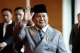 Indonesian President Prabowo Subianto waving while wearing a traditional peci cap