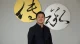 Raffles Family Office CEO Chi-Man Kwan standing in front of decorative calligraphy art